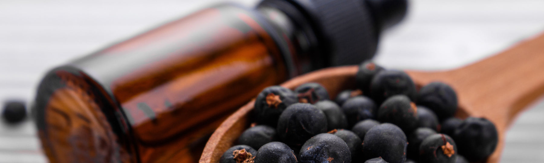 juniper berries wooden spoon amber bottle
