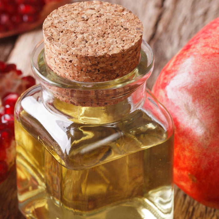 essential oil bottle with pomegranate and seeds