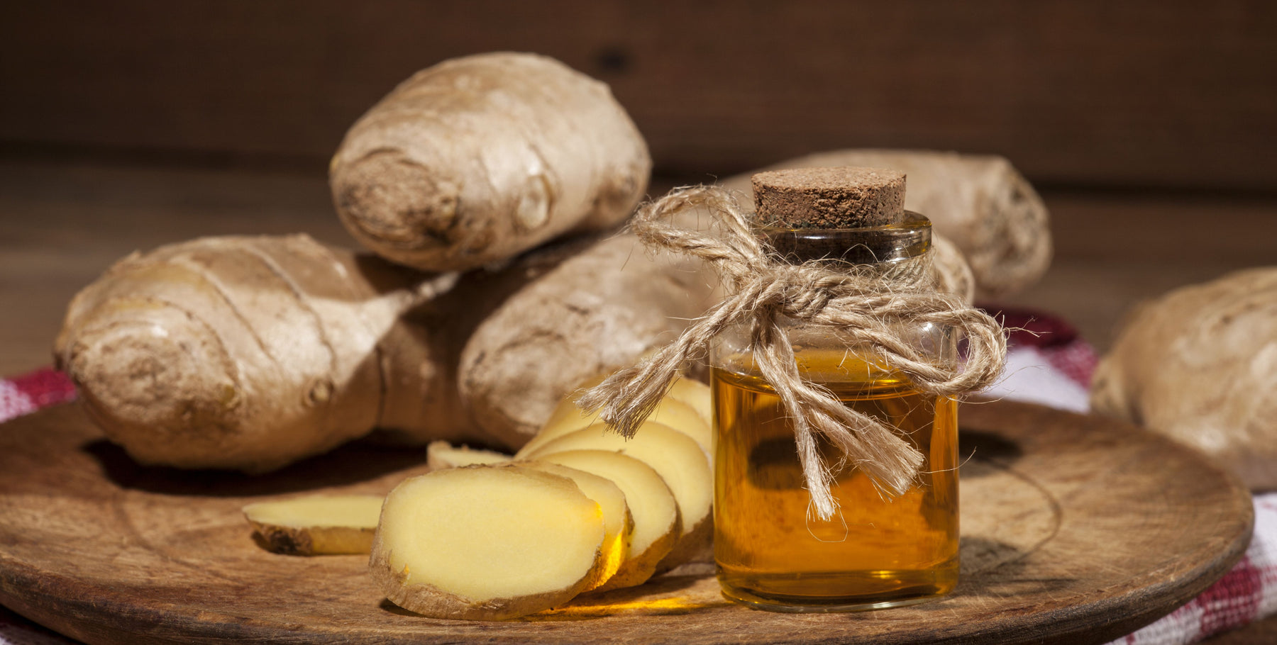 ginger essential oil bottle with sliced and whole ginger