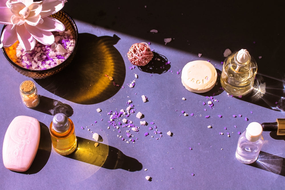 blue lotus oil bottles by blue lotus flower on purple background