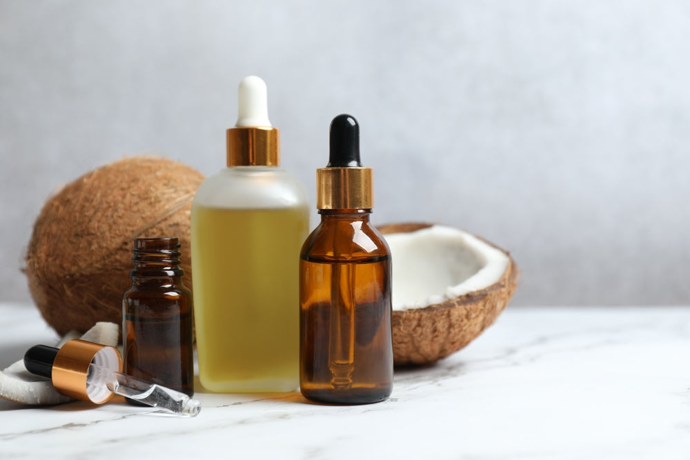 bottle of coconut oil next to split coconut