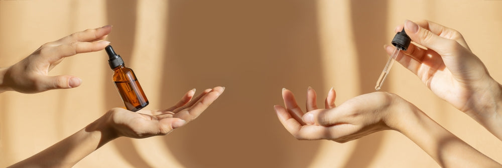 four female hands holding essential oil bottles