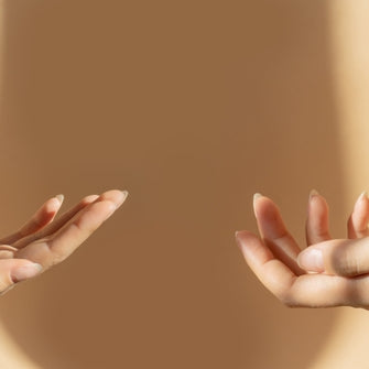 four female hands holding essential oil bottles