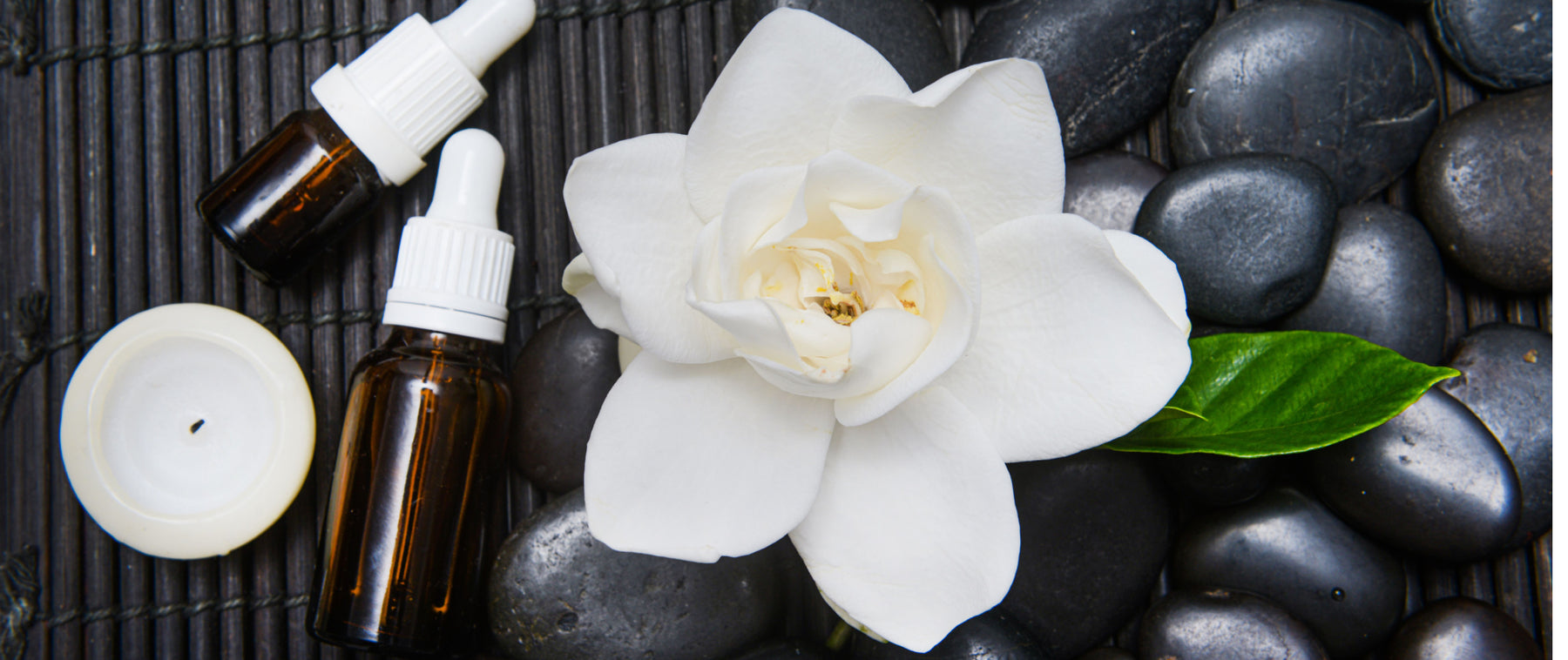 gardenia with oil bottles stones and candle