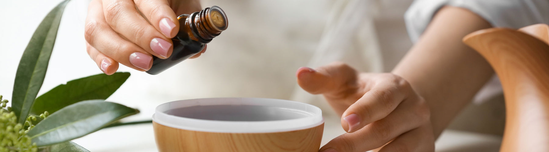 woman adding essential oil to diffuser