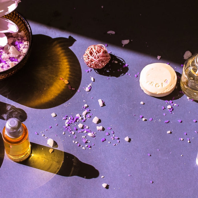 blue lotus oil bottles by blue lotus flower on purple background