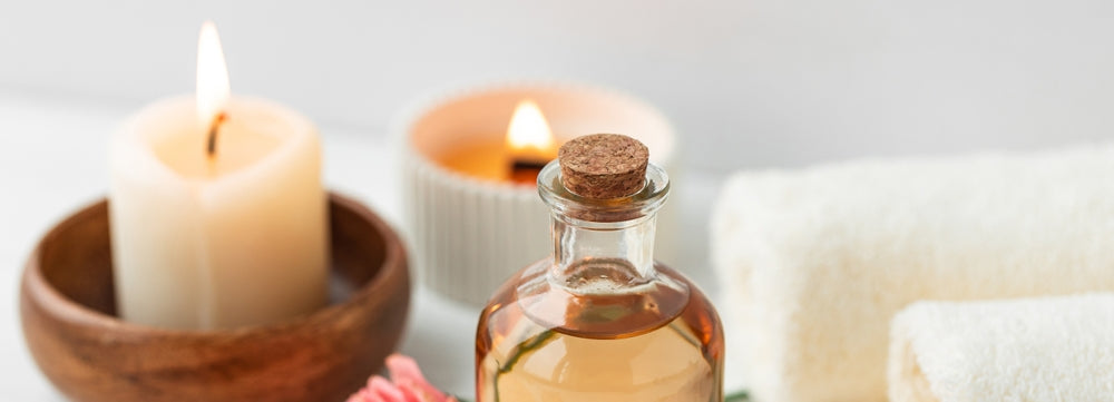 essential oil by scented candles on white table